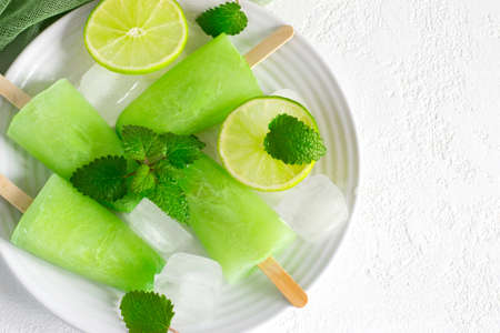 Healthy lime mint popsicles with fresh lime slices And ice cubes. Top view with copy spaceの写真素材