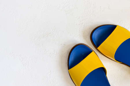 Female youth bright Yellow blue varnished summer sandals on a white background. Top view with copy spaceの写真素材