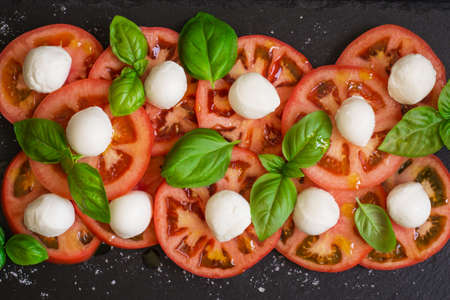 Fresh italian caprese salad on dark plate. Top view.の写真素材