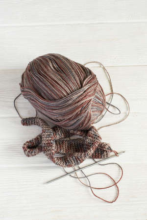 Knitted fabric in Gray winter tones, Ball of threads and crochet hook.