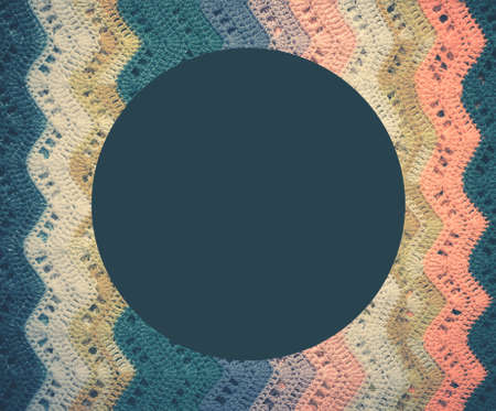 Knitted multicolored cotton fabric In cold blue tones. Round blue frame for text. Vintage toning