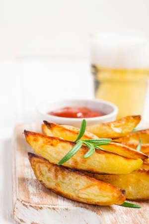 Baked fried potatoes with red sauce and beer, selective focus.