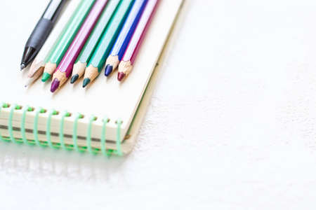 Notepad for drawing and set of pencils in natural purple green tones.の写真素材