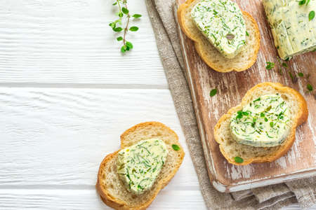 Sandwiches with herbs butter On Cutting board on white wooden background.の写真素材