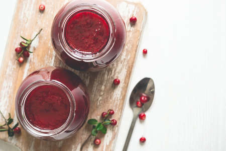 Lingonberry jam in jars and fresh berries. Selective focus, copy space.の写真素材