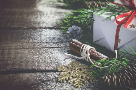 Vintage Christmas gift and coniferous Branches on an old wooden background. Toned.の写真素材