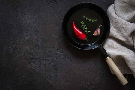 small portioned frying pan on a black stone table. Dark Cooking background.