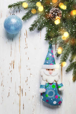 Christmas tree branch with blue toys on white wooden background.の写真素材