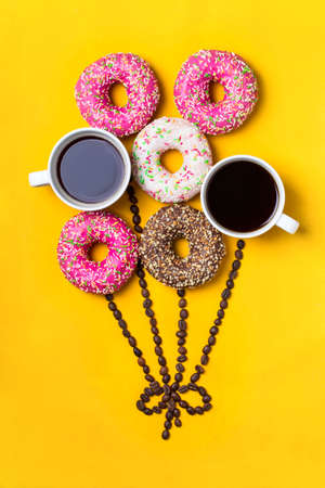 Balloon with donuts and cups of coffee on yellow background.の写真素材