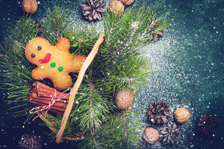 Christmas card with gingerbread man and coniferous branches in basketの写真素材