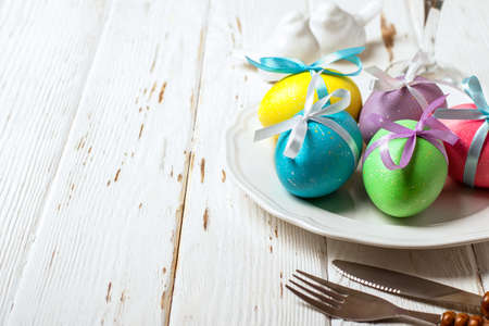 Spring Easter Table setting on white wooden table.