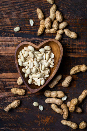 Peanuts snack in bowl on dark background. 