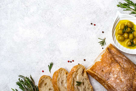 Italian ciabatta bread cut in slices with herbs and olives.の写真素材