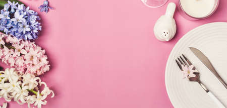 Spring festive Table setting with hyacinth flowers on a pink backgroundの写真素材