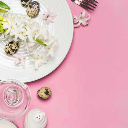 Spring Easter Table setting with hyacinth flowers on a pink background.