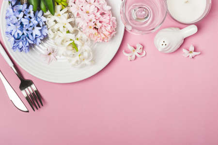 Spring festive Table setting with hyacinth flowers on a pink background.の写真素材