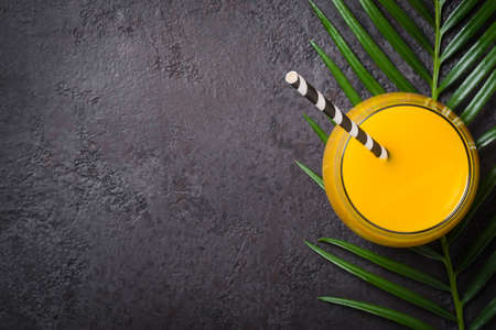 Tropical drink and palm branch on a black background.の写真素材