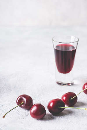 Cherry alcohol drink liquor or brandy on a pink background