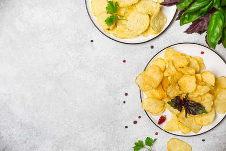 Crispy potato chips and spices on a gray background.の写真素材