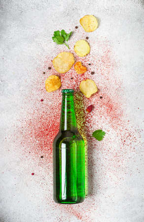 Beer bottle and crispy potato chips on a gray background.の写真素材