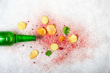 Beer bottle and crispy potato chips on a gray background.の写真素材