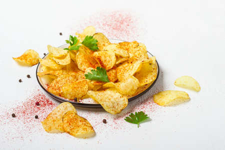 Crispy potato chips on a plate on a white background.の写真素材