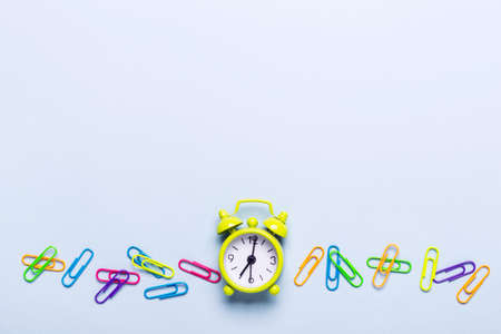 School supplies and alarm clock on a blue background. Back to school concept.の写真素材