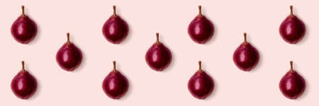Pink purple pears on pink background. Minimalist style. Autumn harvest concept. Pastel colors...