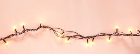 Yellow garland on a pink background. Holiday Christmas concept. Banner format