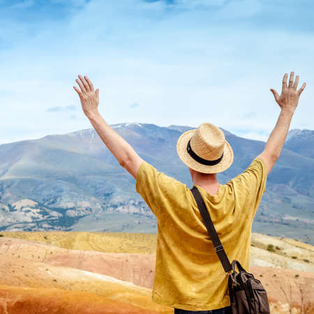 Man tourist in a hat looks at Altai mountain landscape.の写真素材