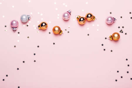 Holiday Christmas pink background with golden shiny balls and confetti.の写真素材