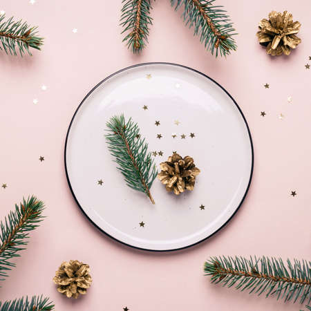 Christmas natural table setting. White plate and confetti on a pink backgroundの写真素材