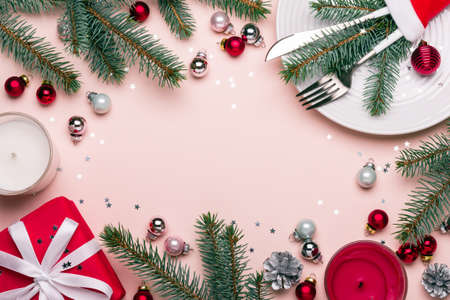 Christmas festive frame with Christmas decorations in red, pink and green colors. Celebration table settingの写真素材