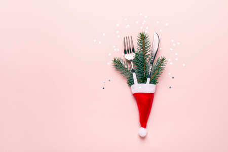 Christmas festive table setting. Fir branches and cutlery in Santa hat.の写真素材