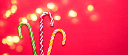 Christmas candy canes on red background and bokeh lights.の写真素材