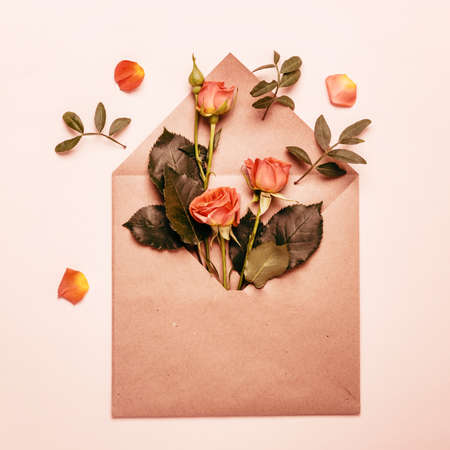 Spring concept. Paper envelope with mini coral roses. Tinted.の写真素材