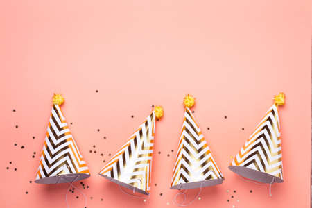Birthday holiday party concept. Striped golden cones hats and confetti.の写真素材