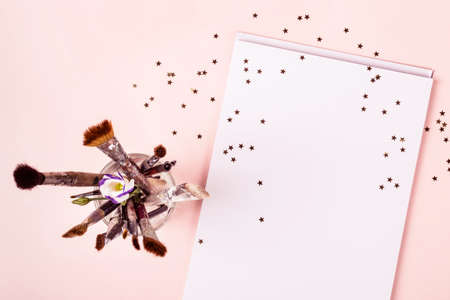 Drawing album, brushes and golden stars on pink background.の写真素材
