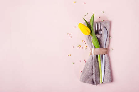 Spring Easter table setting. Cutlery is decorated with beautiful yellow tulip flower.の写真素材