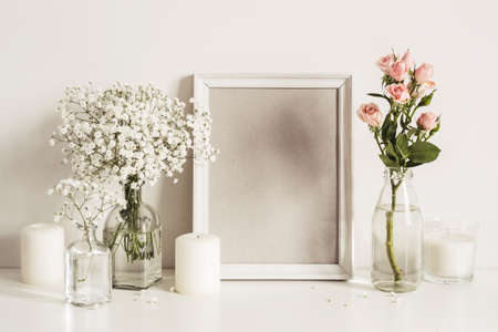 Photo frame, flowers and candles on table wallの写真素材