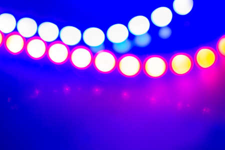 Purple blue neon garlands of bokeh lights and reflections. Festive Abstract background of 80s...