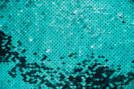 Round iridescent turquoise sequins on fabric.の写真素材