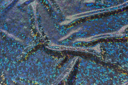 Dark blue fabric with folds and holographic elements.