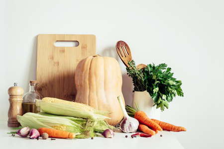 Autumn seasonal vegetables and kitchen utensils still life on table wallの写真素材