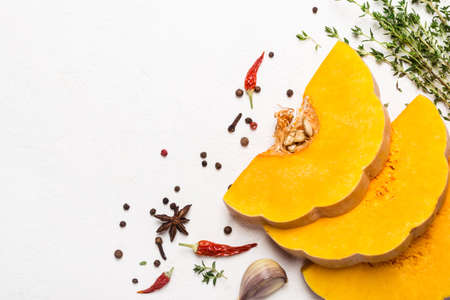 Slices of ripe pumpkin with spices and olive oil.