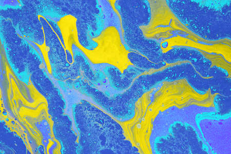 Acrylic Fluid Art. Free flow of yellow and blue colors creates marble effect. Abstract background or...