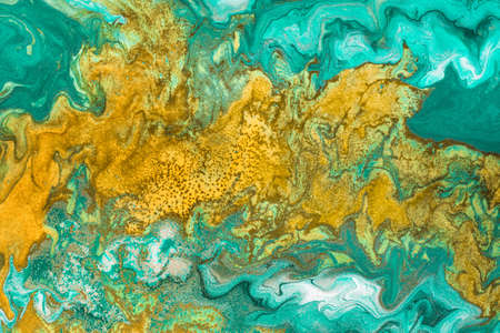Abstract yellow waves on green background with golden inclusions. Free flowing paint. Acrylic fluid...