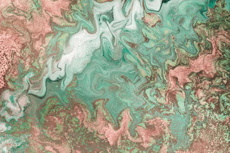 Pink gold grains are randomly scattered on Free flowing paint. Pastel background or texture in mint...