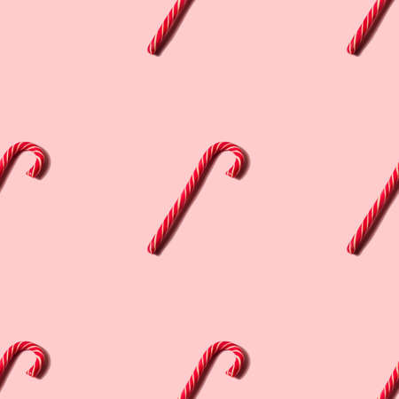 Seamless Christmas texture made of candy cane and shadow on pink