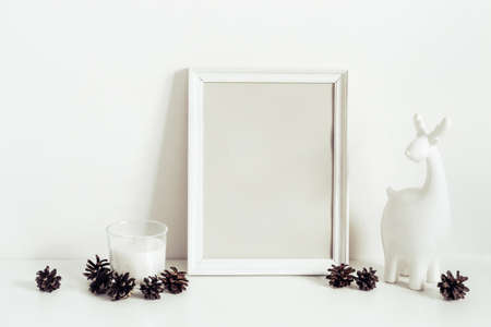 Winter Composition with frame, deer and candle. Minimalist interior decoration. Copy space for lettering.の写真素材